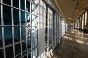 Sun and shadows form on the bars of a prison